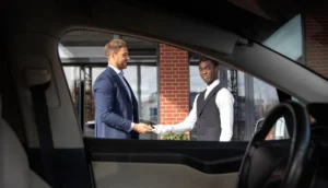NYC Airport Transfers with ZechionRide – Reliable, Premium & Stress-Free Travel (2025 Guide) 8 Chauffeur receiving payment from an executive client, highlighting ZechionRide’s professional and premium corporate transportation services in NYC.