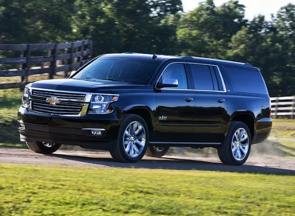 Chevrolet Suburban driving on a scenic rural road, highlighting luxury SUV travel for NYC limousine services and point-to-point transfers.