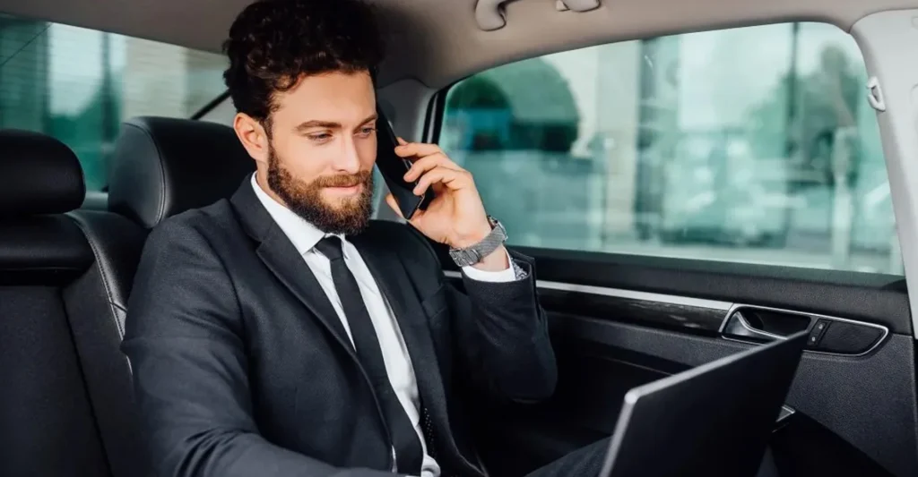 Corporate Travel 4 Businessman in a suit using his laptop, & make a limo booking on call for corporate travel