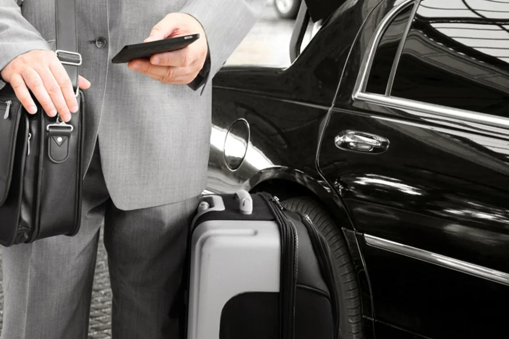 Corporate Travel 5 Man in a suit hold a cell phone and suitcase, preparing for corporate travel in a limousine