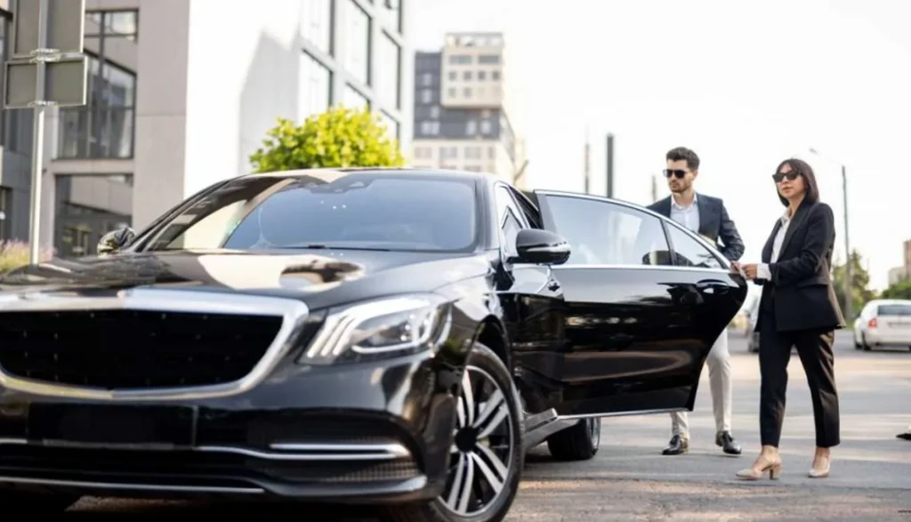 Man and woman stand beside a luxurious black Mercedes SUV, showcasing a premium car service experience
