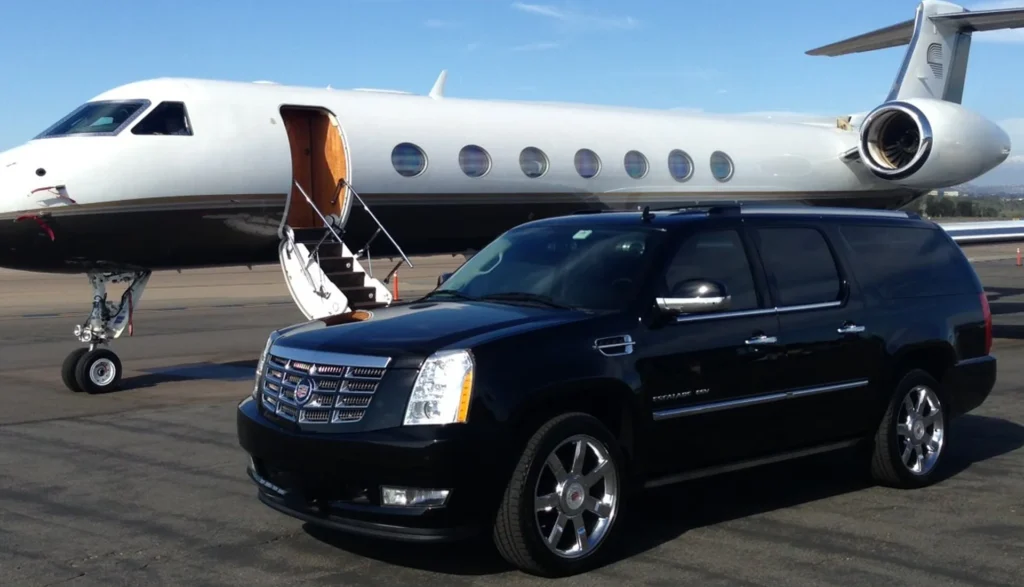 Sleek black Cadillac SUV next to a private jet, highlighting premium transportation choices at LAX in Los Angeles