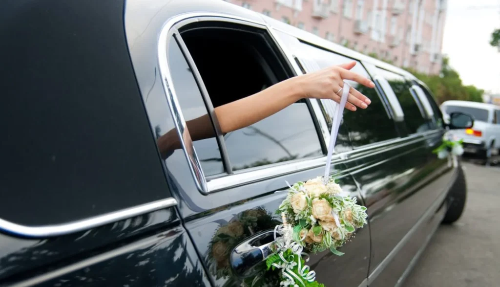 Woman holds a bouquet out of a limo window, showcasing luxury and elegance in a premium vehicle rental experience
